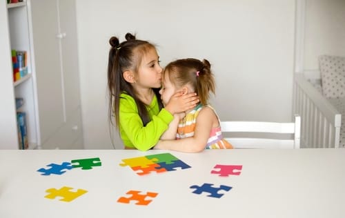 Picture of little girl kissing her little sister